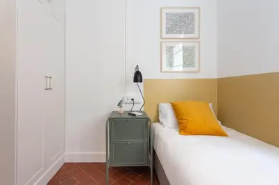 a bedroom with a bed and a yellow pillow at Casa Cosi - Sant Gervasi 1 in Barcelona