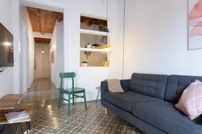 a living room with a blue couch and a green chair at Casa Cosi - Sant Gervasi 1 in Barcelona