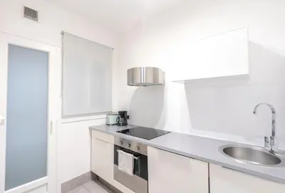 a kitchen with white cabinets and a sink at Nordic apartment Sagrada Familia in Barcelona