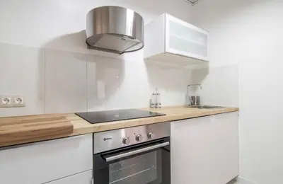 a white kitchen with a sink and a stove at Nordic Apartment II Sagrada Familia in Barcelona