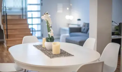 a white dining table with two candles and white chairs at Poble Nou II You Stylish Apartments in Barcelona