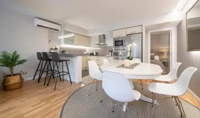 a kitchen and dining room with a white table and chairs at Poble Nou II You Stylish Apartments in Barcelona