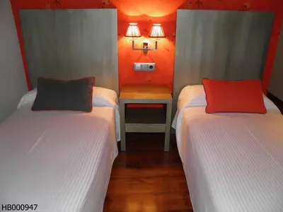 a room with two beds and a small table at Hotel Annex - Rey Don Jaime I in Barcelona