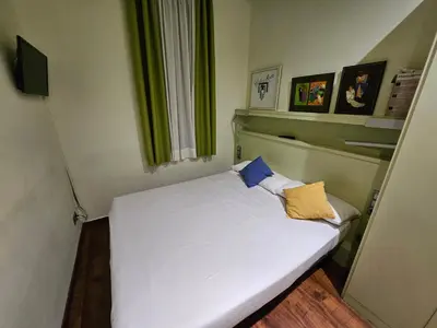 a small bedroom with a white bed with two pillows at Hotel Annex - Rey Don Jaime I in Barcelona