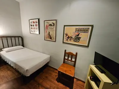 a bedroom with a bed and a tv and a chair at Hotel Annex - Rey Don Jaime I in Barcelona