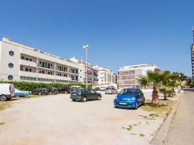 a parking lot with cars parked in front of a building at Sol & Relax en centro, Sitges. in Sitges