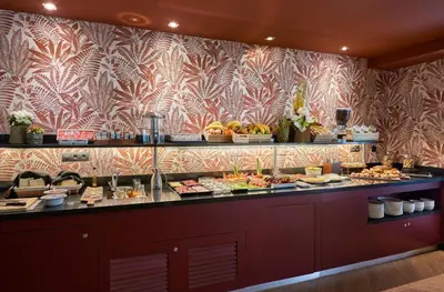 a buffet line with food on display in a restaurant at The Moods Oasis in Barcelona