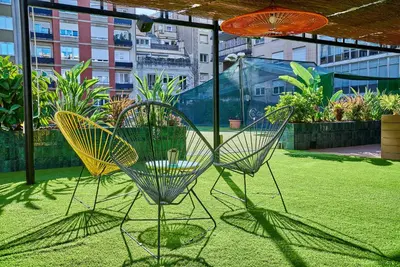 two chairs sitting on top of a yard with grass at The Moods Oasis in Barcelona