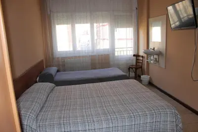 a bedroom with two beds and a window at Hostal Cal Siles in El Prat de Llobregat
