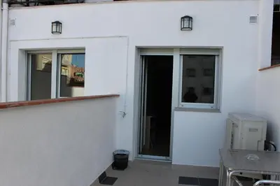 a white building with a door and windows at Hostal Cal Siles in El Prat de Llobregat
