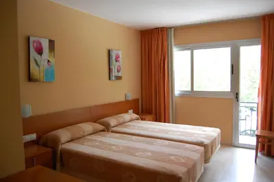 a bedroom with two beds and a window at Hostal Cal Siles in El Prat de Llobregat