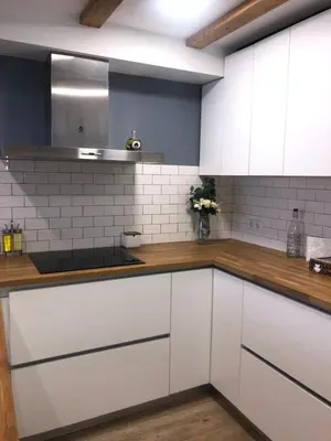 a kitchen with white cabinets and wooden counter tops at Vilamarlux III in Vilassar de Mar