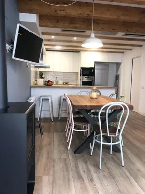 a kitchen and dining room with a wooden table and chairs at Vilamarlux III in Vilassar de Mar