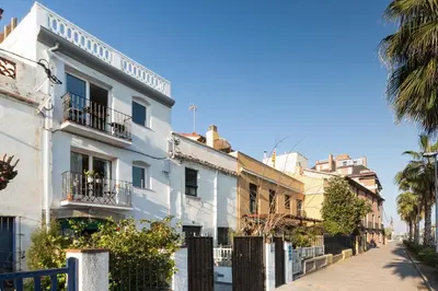 a white building on a street with palm trees at Vilamarlux III in Vilassar de Mar