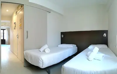 two beds in a room with white sheets and pillows at ClassBedroom Gothic Ramblas Apartments in Barcelona