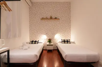 two beds in a small room with white walls at The Central House Barcelona Gracia in Barcelona