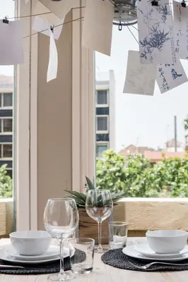a table with glasses and plates on a table with a window at El Alma de las Ramblas in Barcelona