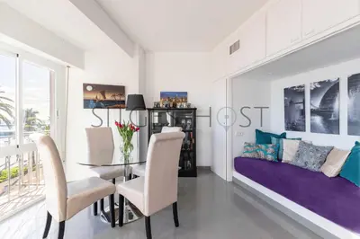 a dining room with a table and a couch at Magnificas vistas al mar in Sitges