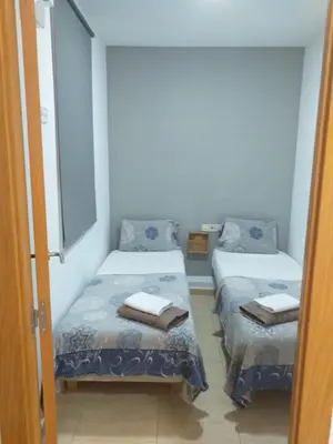 two beds in a small room with towels on them at Mejor Apartamento en Plaza España con Parking Gratuito in Barcelona