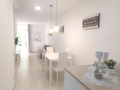 a dining room with a white table and white chairs at Mejor Apartamento en Plaza España con Parking Gratuito in Barcelona