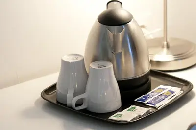 a tray with a coffee pot and cups on a counter at Hostal Live Barcelona in Barcelona