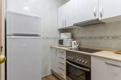a kitchen with white appliances and a white refrigerator at AB Passeig de Gràcia Còrsega in Barcelona