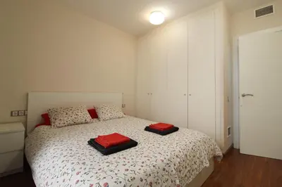 a bedroom with a bed with two red pillows on it at Girona 108 in Barcelona