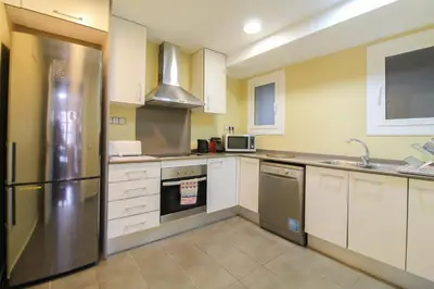 a kitchen with white cabinets and a stainless steel refrigerator at Girona 108 in Barcelona