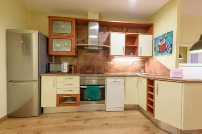 a kitchen with white cabinets and a refrigerator at RamblasRentals Chic & Spacious Flat Pool Table 15M Ramblas - Parking - Wifi in Barcelona