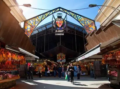 a group of people walking through a market at RamblasRentals Cozy Renovated 2BR with Balcony Lift 20M Rambla - Parking - Wifi in Barcelona