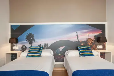 two beds in a room with a painting on the wall at BCNGOTIC 50 in Barcelona