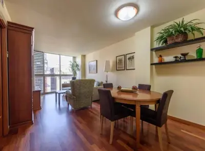 a living room with a wooden table and chairs at RamblasRentals Stylish Bright 3BR New Catalan Flat 10m Ramblas - Parking - Wifi in Barcelona