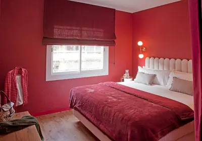 a red bedroom with a bed and a window at Isabella's House in Barcelona