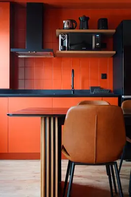 a kitchen with a table and some orange walls at Isabella's House in Barcelona