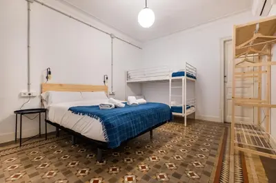 a bedroom with a bed and a bunk bed at b42 - MODERNIST APARTMENT FOR LARGE GROUPS IN EIXAMPLE in Barcelona