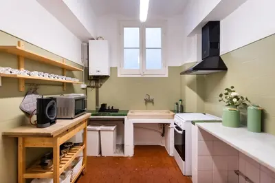 a kitchen with green and white walls and white counters at b42 - MODERNIST APARTMENT FOR LARGE GROUPS IN EIXAMPLE in Barcelona