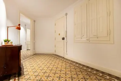 a hallway with white walls and a tile floor and a door at b42 - MODERNIST APARTMENT FOR LARGE GROUPS IN EIXAMPLE in Barcelona