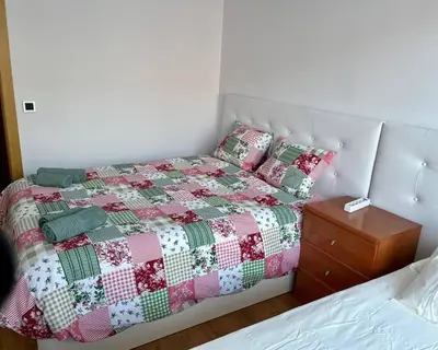 a bedroom with a bed with a quilt and a night stand at Amplio Apartamento cerca de FIRA y del Centro in Hospitalet de Llobregat