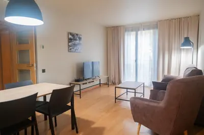 a living room with a table and chairs and a television at Apartments Hotel Sant Pau in Barcelona