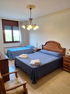 a bedroom with two beds and a chandelier at Cal Llopet in Can Cartro