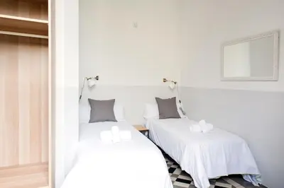 a bedroom with two beds with white sheets at My Address in Barcelona in Barcelona