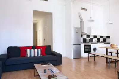 a living room with a blue couch and a kitchen at My Address in Barcelona in Barcelona