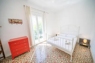 a bedroom with a white crib and a red dresser at HomeHolidaysRentals Arlene in Calella