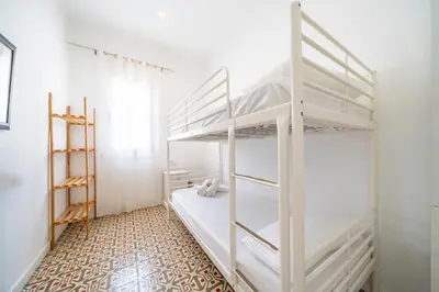 a bedroom with two bunk beds and a tiled floor at HomeHolidaysRentals Arlene in Calella