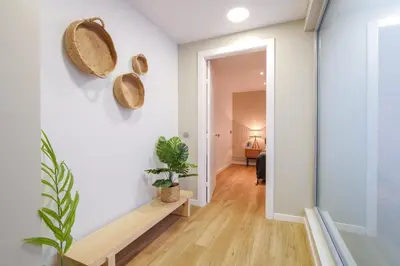 a hallway of a home with white walls and a plant at Sweett - Verdi in Barcelona