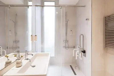 a white bathroom with a sink and a shower at Murmuri Residence Concepció in Barcelona