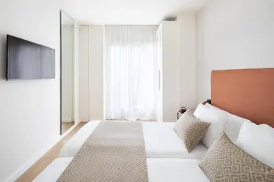 a hotel room with a bed and a television at Murmuri Residence Concepció in Barcelona