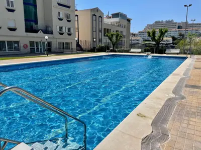 a large blue swimming pool in a building at La Marina SeaView Penthouse in Sitges