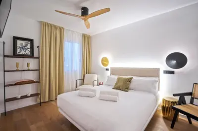 a bedroom with a white bed with a ceiling fan at Hotel Casa Trafalgar Barcelona in Barcelona