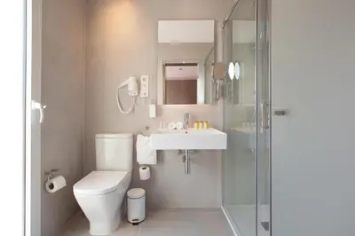 a bathroom with a toilet and a sink and a shower at Hotel Casa Trafalgar Barcelona in Barcelona